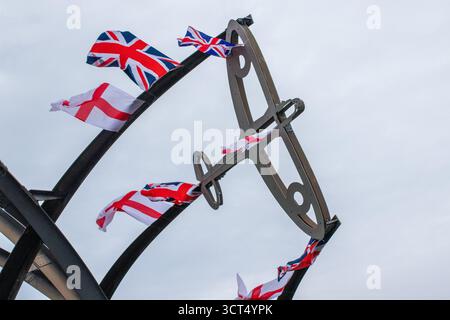 Des drapeaux patriotiques ont été placés sur l'île Spitfire à Birmingham, au Royaume-Uni. Les drapeaux de l'Union Jack et de l'Angleterre ont été drapés sur la sculpture Sentinel qui se trouve près du site où les emblématiques avions Spitfire ont été produits pendant la seconde Guerre mondiale. Sentinel est une sculpture de 16 mètres de haut (52 pieds) de Tim Tolkien, installée sur l'île Spitfire, un rond-point à l'intersection de la route Chester et de l'A47 Fort Parkway à l'entrée du domaine Castle Vale à Birmingham, en Angleterre. Banque D'Images
