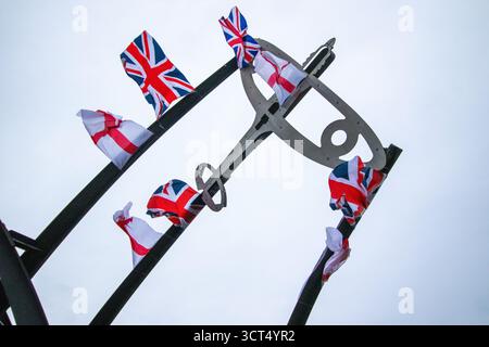 Des drapeaux patriotiques ont été placés sur l'île Spitfire à Birmingham, au Royaume-Uni. Les drapeaux de l'Union Jack et de l'Angleterre ont été drapés sur la sculpture Sentinel qui se trouve près du site où les emblématiques avions Spitfire ont été produits pendant la seconde Guerre mondiale. Sentinel est une sculpture de 16 mètres de haut (52 pieds) de Tim Tolkien, installée sur l'île Spitfire, un rond-point à l'intersection de la route Chester et de l'A47 Fort Parkway à l'entrée du domaine Castle Vale à Birmingham, en Angleterre. Banque D'Images