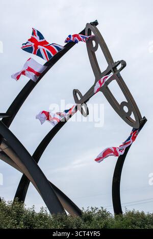 Des drapeaux patriotiques ont été placés sur l'île Spitfire à Birmingham, au Royaume-Uni. Les drapeaux de l'Union Jack et de l'Angleterre ont été drapés sur la sculpture Sentinel qui se trouve près du site où les emblématiques avions Spitfire ont été produits pendant la seconde Guerre mondiale. Sentinel est une sculpture de 16 mètres de haut (52 pieds) de Tim Tolkien, installée sur l'île Spitfire, un rond-point à l'intersection de la route Chester et de l'A47 Fort Parkway à l'entrée du domaine Castle Vale à Birmingham, en Angleterre. Banque D'Images