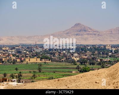 LOUXOR, EGYPTE : vue panoramique sur les gratte-ciel de Louxor le long du Nil, lumière du soleil reflétant l'eau et l'architecture historique de la ville Banque D'Images