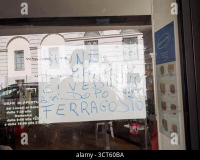 Cremona, Italie 29 juillet 2025 signe manuscrit sur une fenêtre de restaurant en Italie communiquant la fermeture pour les vacances d'été après Ferragosto, reflétant Banque D'Images