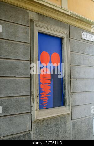 Cremona, Italie - 30 septembre 2025 murale artistique vibrante représentant deux figures silhouettées sur un fond bleu saisissant avec un Re orange abstrait Banque D'Images