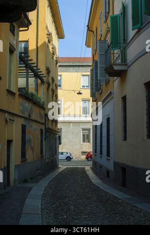 Cremona, Italie - 30 septembre 2025 ruelle pavée étroite à Crémone Italie bordée de bâtiments jaunes historiques avec volets verts et Di Banque D'Images