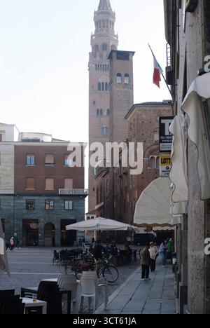 Crémone, Italie - 30 septembre 2025 charmante place italienne à Crémone avec le Campanile historique de Torrazzo surplombant les cafés extérieurs et la rue pavée Banque D'Images