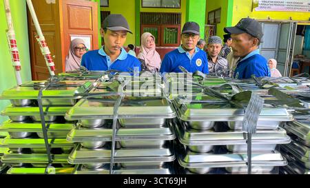 Klaten, Indonésie - le 25 septembre 2025, les agents de SPPG, les agents de déjeuner gratuits distribuent des conteneurs de nourriture Banque D'Images