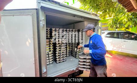 Klaten, Indonésie - le 25 septembre 2025, les agents de SPPG, les agents de déjeuner gratuits distribuent des conteneurs de nourriture Banque D'Images