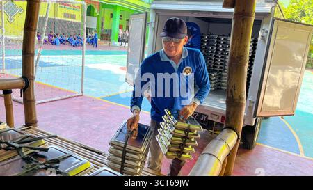 Klaten, Indonésie - le 25 septembre 2025, les agents de SPPG, les agents de déjeuner gratuits distribuent des conteneurs de nourriture Banque D'Images