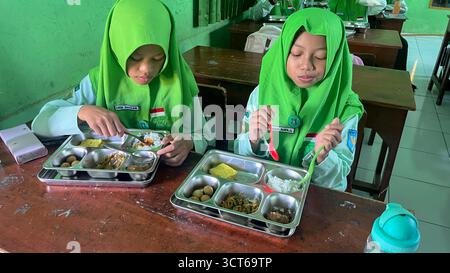 Klaten, Indonésie - le 25 septembre 2025 les élèves de madrasah tsanawiyah de niveau secondaire en Indonésie déjeunent dans la salle de classe pendant Banque D'Images