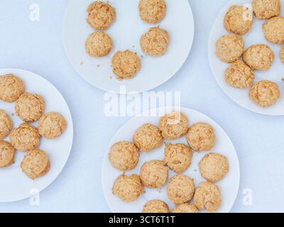 Pâtisseries dorées croustillantes au choux sur une assiette blanche, élégant dessert français servi lors d'un événement d'entreprise sur le toit à Paris. Banque D'Images