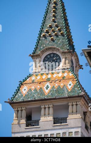 Tour de l'horloge du bâtiment de la préfecture avec toit en tuiles, près du palais de la culture à Targu Mures. Banque D'Images