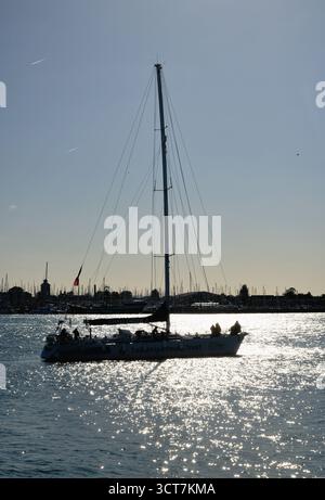 Une silhouette du yacht Tall Ships Youth Trust Challenger 3 naviguant dans le port de Portsmouth Hampshire Angleterre Royaume-Uni Banque D'Images