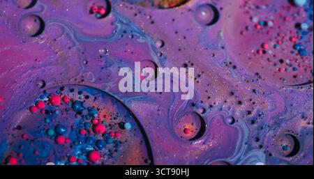Teindre les bulles. Vague de peinture. Défocalisé rose violet bleu coloré gouttelette glitter huile liquide acrylique flottant sur fond d'art abstrait. Banque D'Images