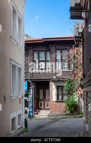 Rue pavée étroite avec maison ottomane traditionnelle en bois, fleurs en fleurs et ciel bleu dans le quartier Sultanahmet d'Istanbul, Turquie. Banque D'Images
