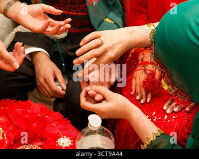 Femme appliquant de la pâte de henné à la main de la mariée pendant la cérémonie kurde-tunisienne de pré-mariage. Banque D'Images