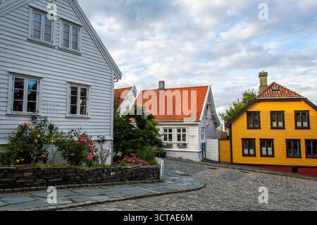 Vue sur la rue historique étroite de Gamle Stavanger Norvège avec des maisons en bois colorées et rue couverte de pavés après le coucher du soleil Banque D'Images