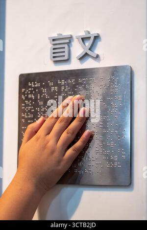 Le braille est un système d’écriture tactile pour les malvoyants, vital pour leur accès à l’information et leur intégration sociale. Banque D'Images