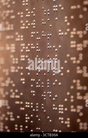 Le braille est un système d’écriture tactile pour les malvoyants, vital pour leur accès à l’information et leur intégration sociale. Banque D'Images