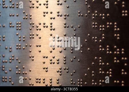 Le braille est un système d’écriture tactile pour les malvoyants, vital pour leur accès à l’information et leur intégration sociale. Banque D'Images
