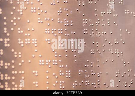 Le braille est un système d’écriture tactile pour les malvoyants, vital pour leur accès à l’information et leur intégration sociale. Banque D'Images