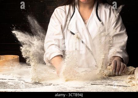 Farine de blé blanc. Pâtes de préparation. Préparation des pâtes à la main. Faire de la pâte par des mains masculines à la boulangerie. Concept alimentaire. Pâte à main. Fabrication des mains Banque D'Images