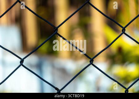 Gros plan de la vieille clôture en treillis métallique rouillée avec un fond flou. Concept de restriction de zone, de sécurité, d'isolement et de barrière. Grille métallique corrodée t Banque D'Images