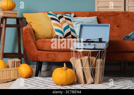Intérieur d'un salon élégant avec canapé, tourne-disque et citrouilles Banque D'Images