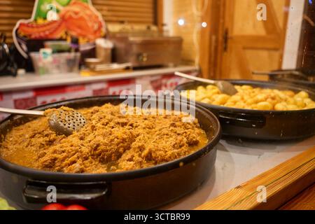 Bigos polonais traditionnels avec de la viande dans une grande casserole et des pommes de terre dans une autre casserole au marché de Noël. Concept de cuisine festive, tradition et St européen Banque D'Images