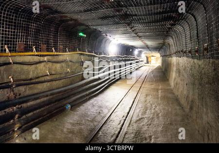 Vue intérieure des tunnels souterrains dans l'ancienne mine avec chemin de fer Banque D'Images