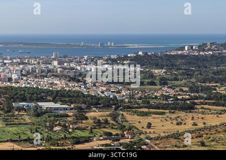 Superbe vue aérienne capturant la ville de Setubal à travers l'estuaire du Sado depuis la péninsule de Tróia, avec les champs environnants et la nature. Banque D'Images