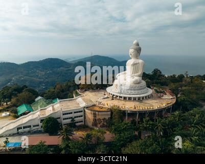 Vue aérienne de la majestueuse statue de Bouddha blanc perchée au sommet d'une colline surplombant une végétation luxuriante et l'océan lointain, Phuket Buddha, Phuket, Thaïlande. Banque D'Images