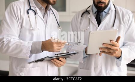 Gros plan deux médecins portent des blouses de laboratoire blanches discutant du cas du patient Banque D'Images