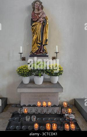 Figure de la Vierge Marie avec l'enfant Jésus, décorations florales et bougies sacrificielles, église paroissiale catholique romaine St Martin, Leutkirch, Allgï¿½ Banque D'Images