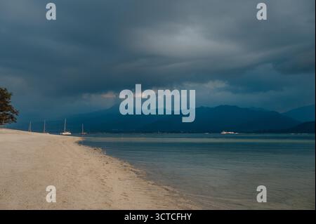 Stormy Sky Over Beach avec des voiliers et Lombok Mountains, Gili Air Banque D'Images