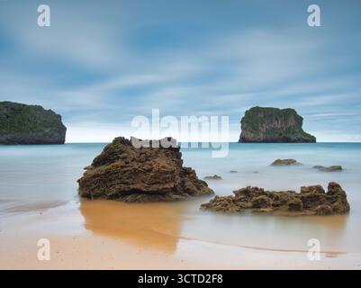 Monolithe côtier Sea Stack dans Smooth Ocean - photo longue exposition d'un monolithe marin recouvert d'herbe s'élevant de l'océan Atlantique, encadré par Smooth Banque D'Images