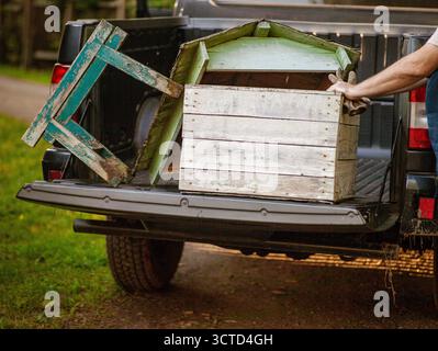 un fermier déplaçant une vieille ruche dans un pick-up, un tir de jour Banque D'Images