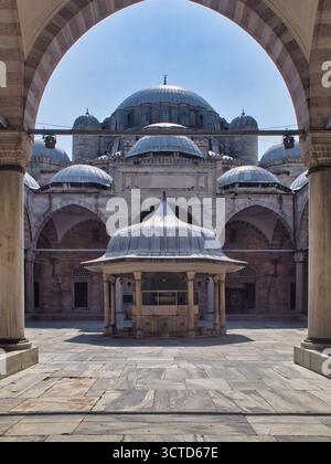 Fontaine et mosquée Cour encadrée par des arches - Une vue symétrique, grand angle d'une fontaine ornée d'ablutions (şadırvan) et les grands dômes d'an O. Banque D'Images