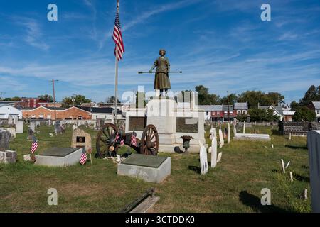 Carlisle, Pennsylvanie, États-Unis – 4 octobre 2025 : tombe de Molly McCauley, mieux connue sous le nom de Molly Pitcher dans le vieux cimetière. Une statue de Molly, debout alon Banque D'Images
