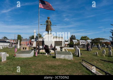 Carlisle, Pennsylvanie, États-Unis – 4 octobre 2025 : tombe de Molly McCauley, mieux connue sous le nom de Molly Pitcher dans le vieux cimetière. Une statue de Molly, debout alon Banque D'Images