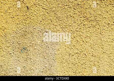 Jaune rugueux vieux mur fissuré. Fond abstrait grunge shabby coloré Banque D'Images