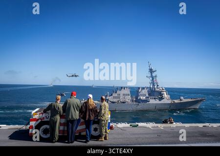 251005-N-SK738-1426 OCÉAN ATLANTIQUE (5 octobre 2025) le président Donald J. Trump et la première dame Melania Trump (au centre) et le chef des opérations navales l'amiral Daryl Caudle (à gauche) observent un MH-60S Seahawk opérer avec le destroyer de missiles guidés de classe Arleigh Burke USS Ross (DDG 71) à bord du porte-avions de classe Nimitz USS George H. W. Bush (CVN 77) lors d'un Titans of the Sea Presidential Review Oct. 05, 2025. La revue présidentielle Titans of the Sea est l’un des nombreux événements organisés dans tout le pays pour présenter les capacités maritimes dans le cadre du 250e anniversaire de la marine américaine. Ameri Banque D'Images