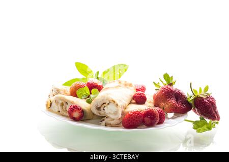Assiette avec crêpes et fraises fraîches sur blanc. Banque D'Images