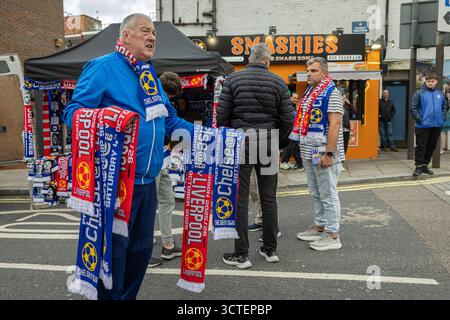 Un vendeur de rue expose des foulards Chelsea FC près du stade de Stamford Bridge avant un match de premier League entre Chelsea et Liverpool. Banque D'Images