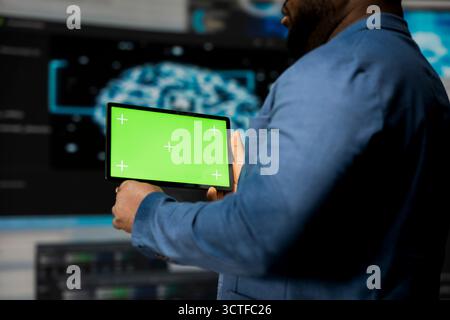 L'expert afro-américain tient le dispositif avec écran maquette avec code binaire en arrière-plan, transformation numérique. Mise en valeur du développement logiciel avec algorithmes, science des données. Banque D'Images