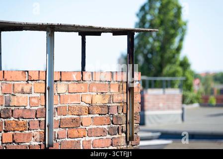 Un gros plan détaillé d'une cheminée en brique altérée sur un toit ensoleillé de Berlin. La faible profondeur de champ met en évidence la texture et crée une zone urbaine floue Banque D'Images