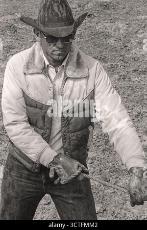 Photo monochrome noir et blanc d'un ouvreur de portail de chute de rodéo ou d'un homme de portail après une tempête de pluie Banque D'Images
