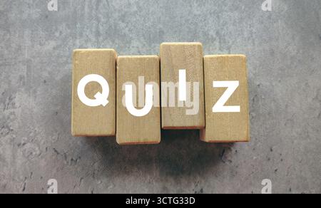 Le QUIZ Word orthographié sur blocs en bois sur un fond gris béton pour l'éducation et le concept de test Banque D'Images