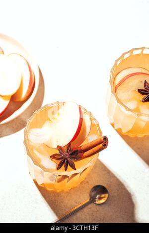 Cocktail de pommes d'automne ou boisson mocktail. Cidre de pomme avec cannelle et anis sur fond blanc, espace de copie. Banque D'Images