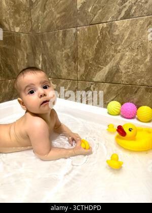 Bébé jouant avec Rubber Ducks dans la baignoire Banque D'Images