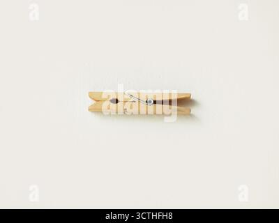 Une pince à vêtements vintage en bois au milieu d'un fond blanc Banque D'Images