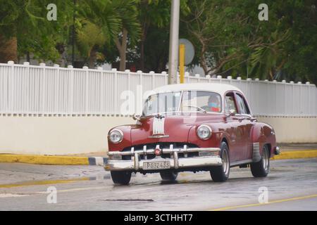 Série 8 argent 1950 de Pontiac. Fleurs de cerisier vintage, voitures rétro roulent le long de la rue centrale de la station cubaine le jour de pluie. Gros plan d'un taxi vintage rouge. Varadero, Cuba - 14 janvier 2022 Banque D'Images